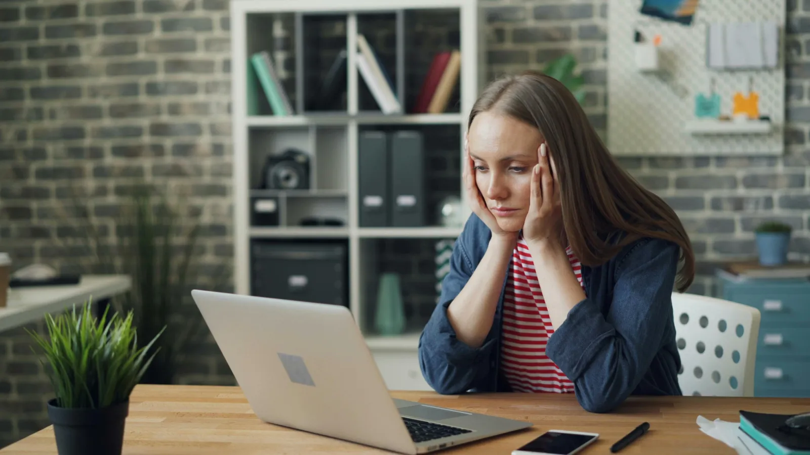 a woman sitting at a table with her hand on her face