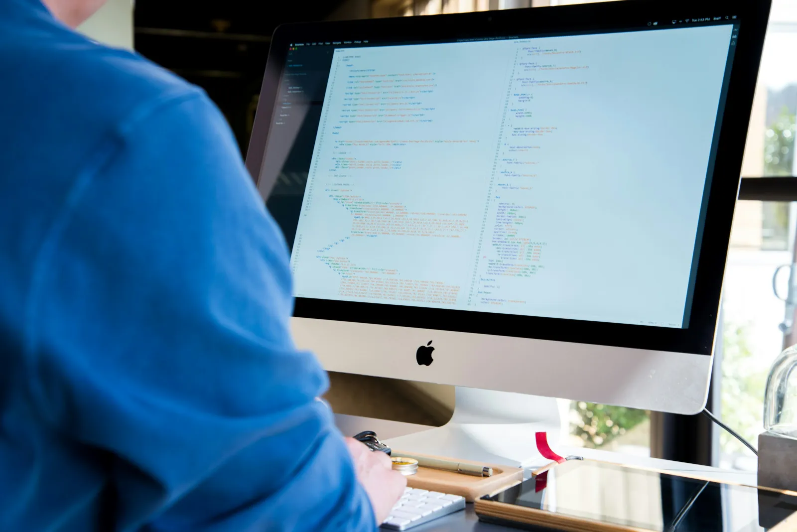 a person in blue scrubs looking at a computer screen